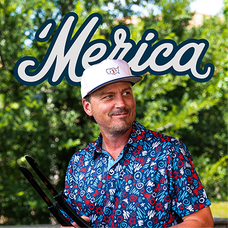 A man in a patterned blue shirt and white cap holds grill tongs, smiling, in front of a bold Merica sign. Green trees form the background, creating a festive outdoor summer vibe.