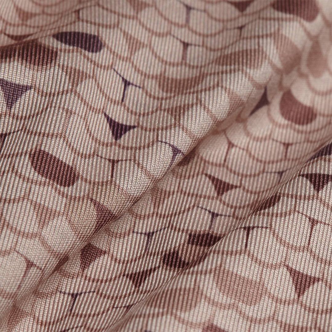 A close-up of the Whale Tail - Sand - Polo shows soft, light pink, ribbed fabric with a repeating geometric pattern of overlapping circles and small triangles, plus moisture wicking properties for comfort.